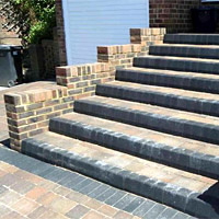 A photo of a small set of stairs and brick wall