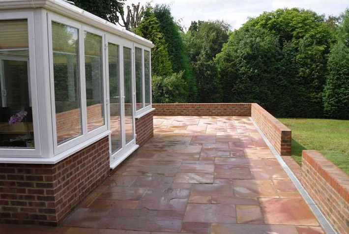 Photo of new patio in sandstone and low brick wall